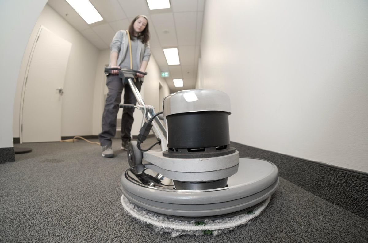 Cleaner maintaining office carpet with a rotary machine in Birmingham