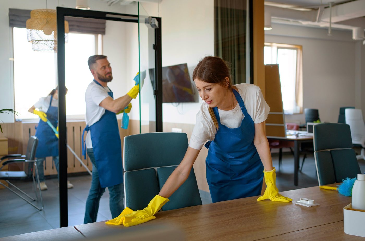 Cleaning team wiping desks and glass partitions in a Birmingham office